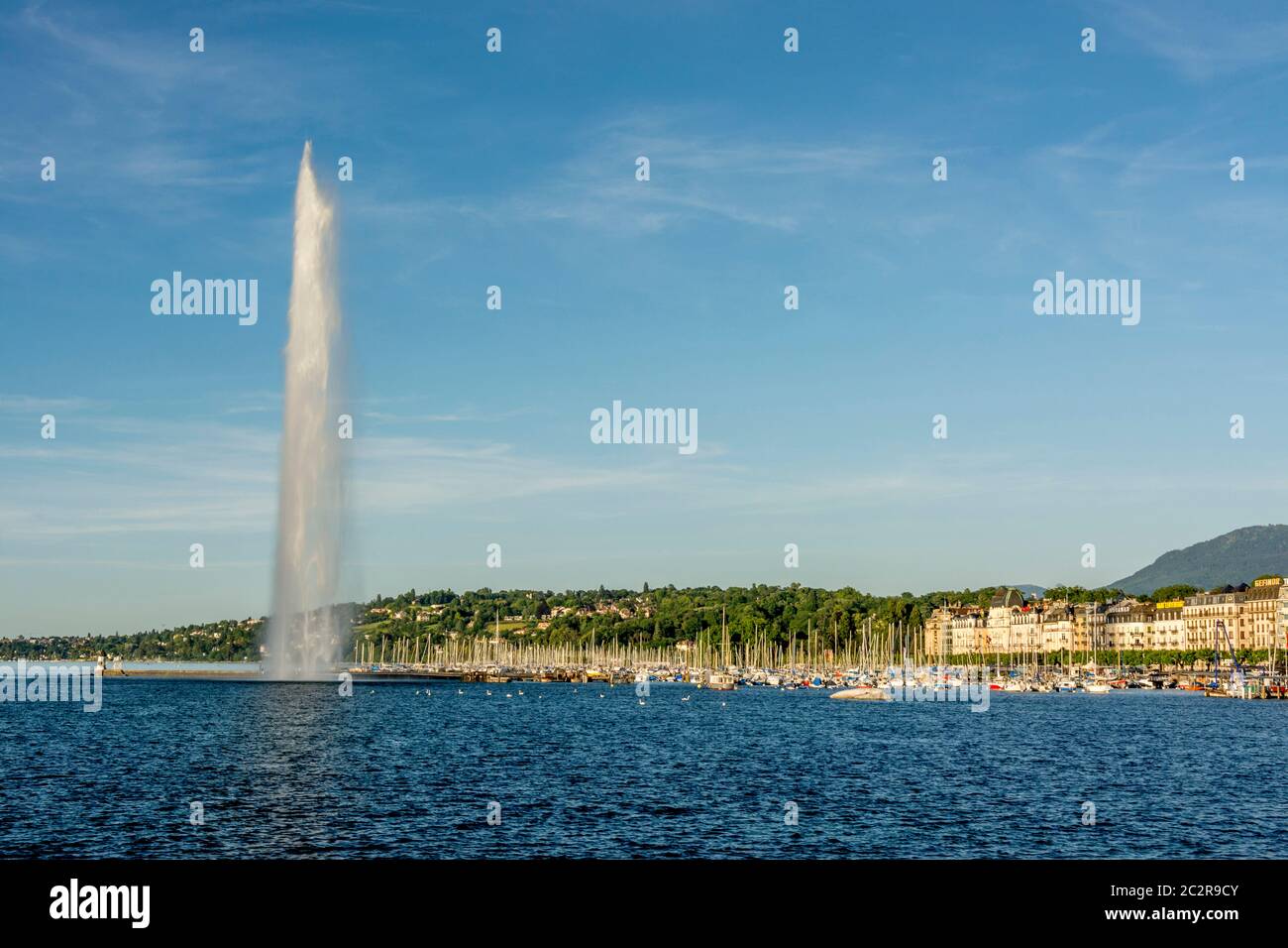 Fontaine jet d'eau dans le lac Léman avec des bateaux et un ciel ensoleillé dans le canton de Genève, Suisse Banque D'Images