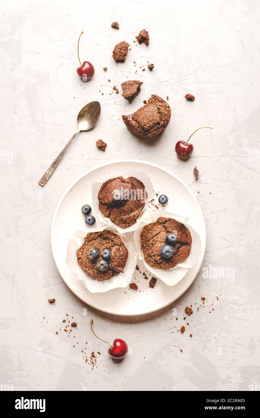 Muffins au chocolat frais faits maison avec baies et morceaux de chocolat. Banque D'Images