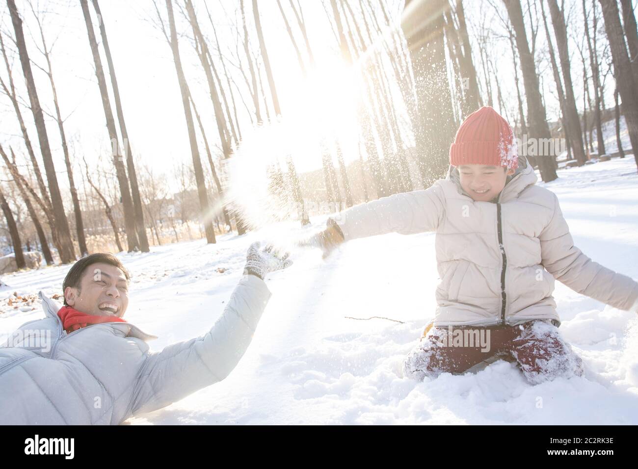 Un père et un fils heureux jouent dans la neige Banque D'Images