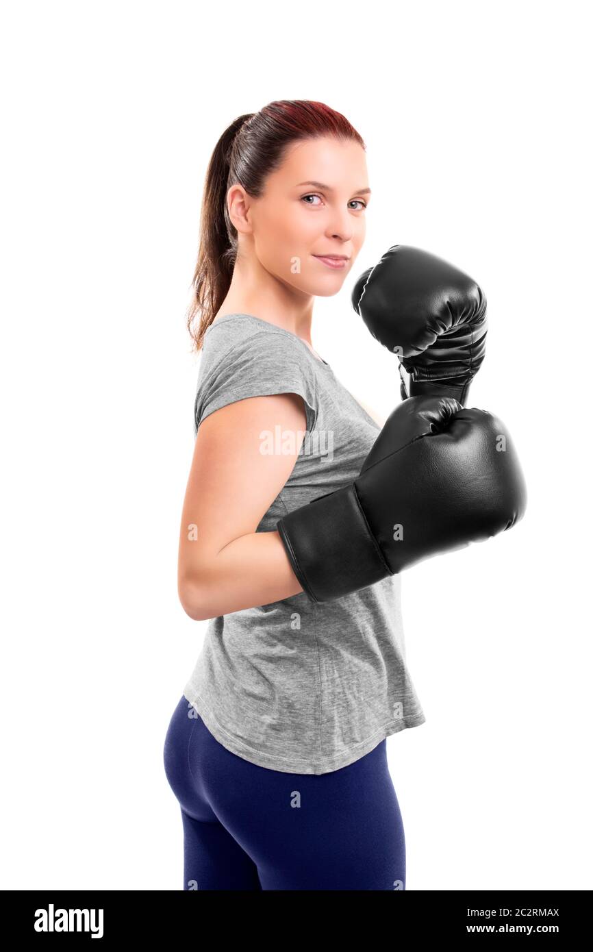 Portrait d'une belle jeune femme avec des gants de boxe dans une position avec les bras levés, isolé sur fond blanc. Banque D'Images