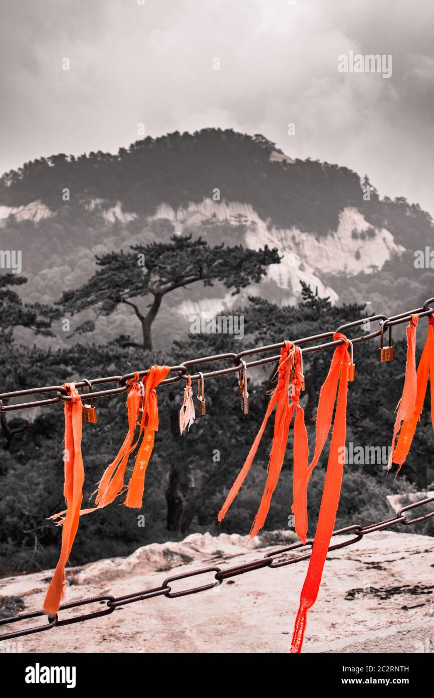 Huashan, Chine - Août 2019 : le ruban rouge attaché à la barrière de protection sur un affût avec le magnifique paysage de montagne vue depuis le sommet Banque D'Images