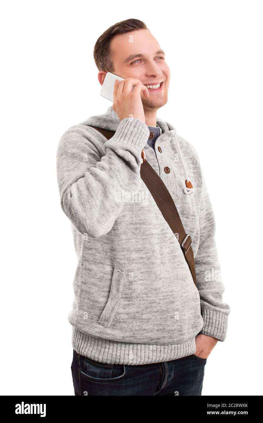 Portrait of a smiling man confiant ou étudiant dans des vêtements décontractés et un sac à bandoulière talking on mobile phone, isolé sur un fond blanc. Banque D'Images