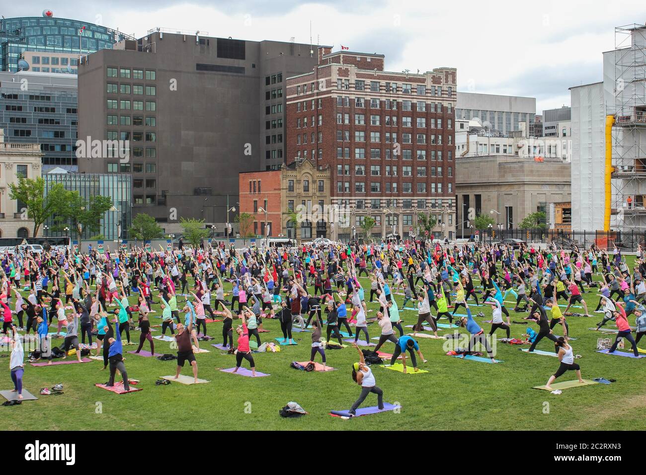 Un grand groupe de personnes donne une leçon de yoga dans un pré urbain à Ottawa, Ontario, Canada Banque D'Images