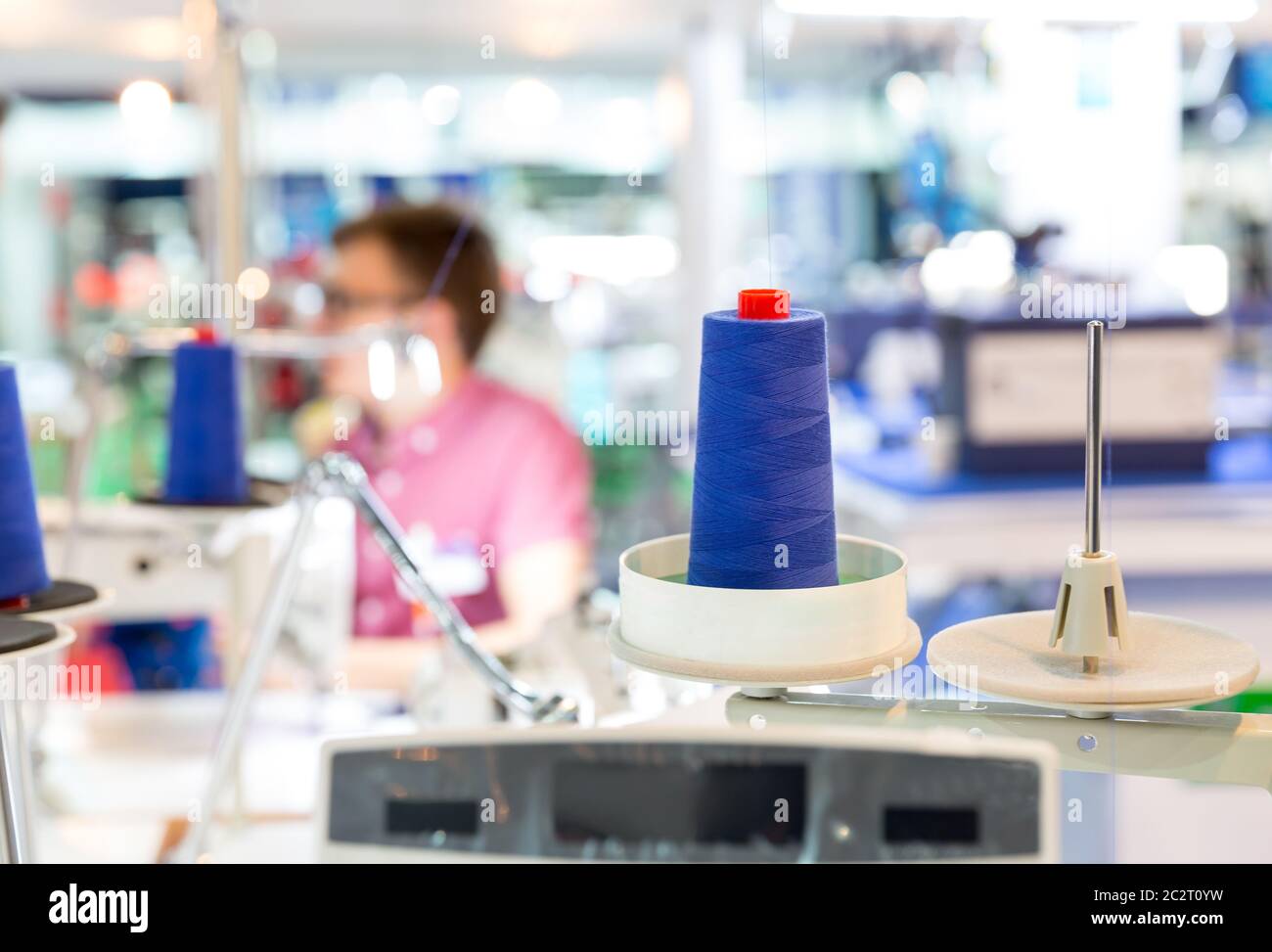 Bobines de fils bleus sur machine à coudre. Usine de tissus, tissage, production textile, industrie du vêtement Banque D'Images