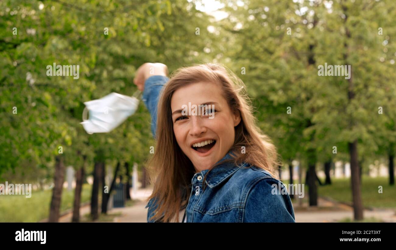 La femme prend le masque médical et se réjouit Banque D'Images La femme prend le masque médical et se réjouit Banque D'Images
