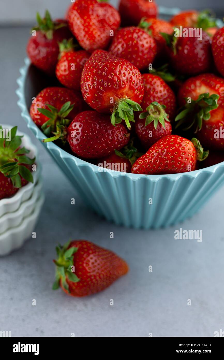 Bol de fraises sur la table de cuisine. Baies dans une assiette blanche. Récolte de fraises. La nourriture reste vie. Rouge baies d'été. Petit déjeuner vitaminé. Banque D'Images