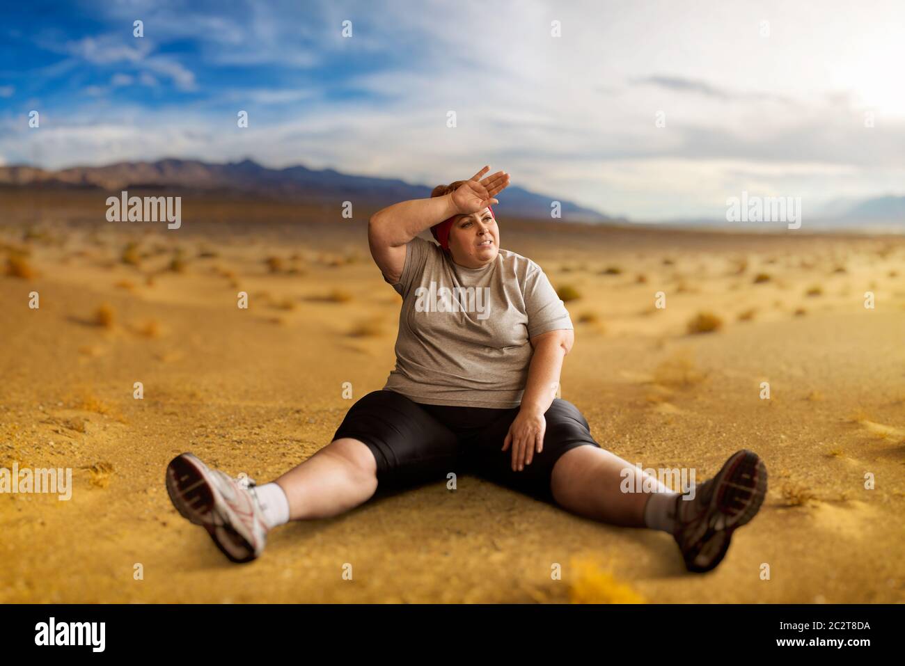 L'excès de femme assise dans la vallée du désert. La combustion des calories. L'obésité féminine, boulimique. Manger des aliments malsains Banque D'Images