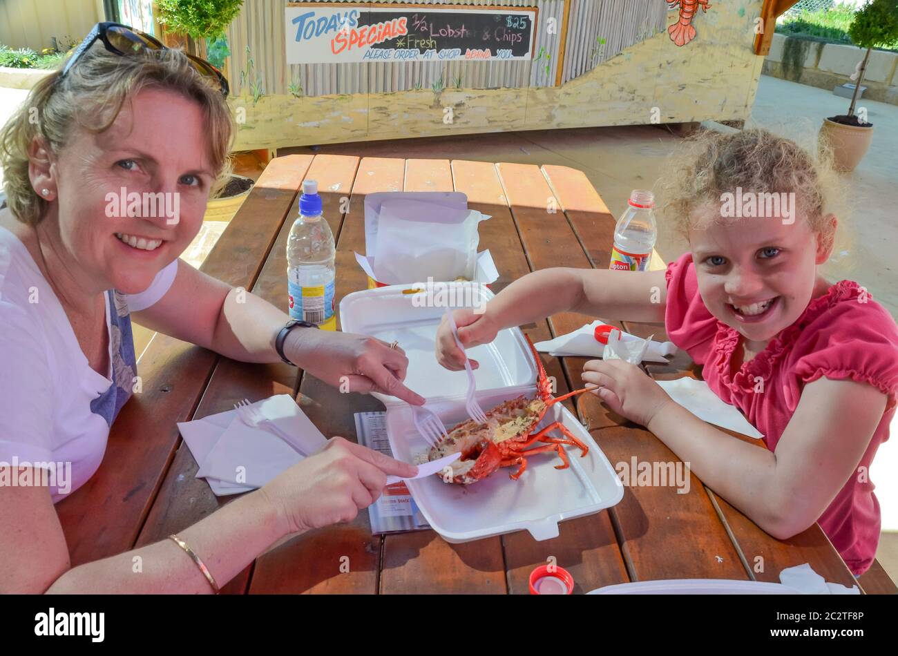 Une mère et une jeune fille australiennes partagent un homard cuit au Lobster Shack dans la ville côtière de Cervantes, en Australie occidentale Banque D'Images
