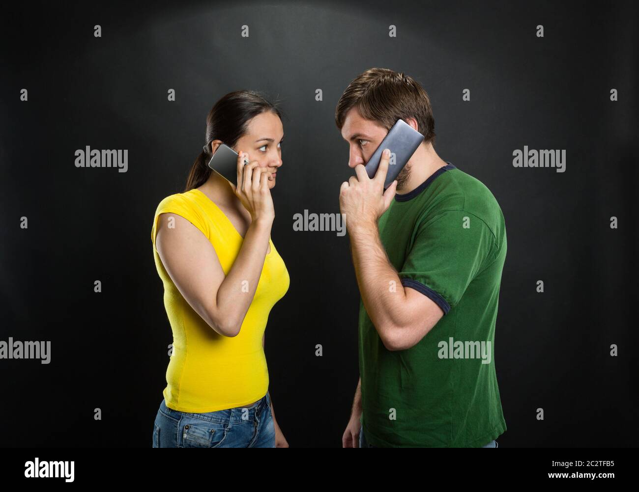 Homme et femme en colère parlant avec un téléphone portable dans la chambre Banque D'Images
