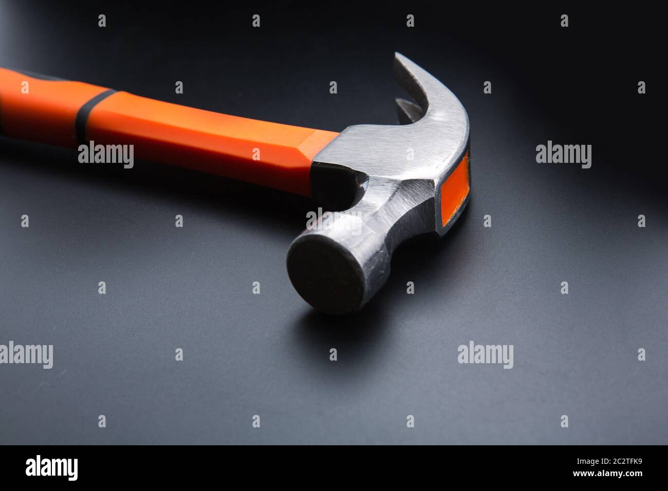 Marteau orange foncé sur fond mat, gros plan, personne. Nouveau hummer, outil de l'atelier Banque D'Images