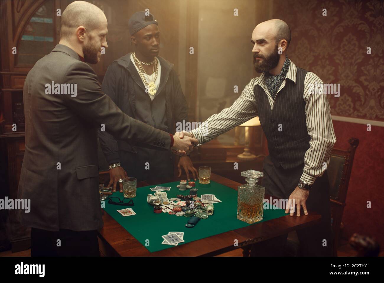 Les joueurs de poker mâles se secouent la main dans le casino. Jeux de hasard addiction, risque, maison de jeu. Hommes loisirs avec whisky et cigares Banque D'Images