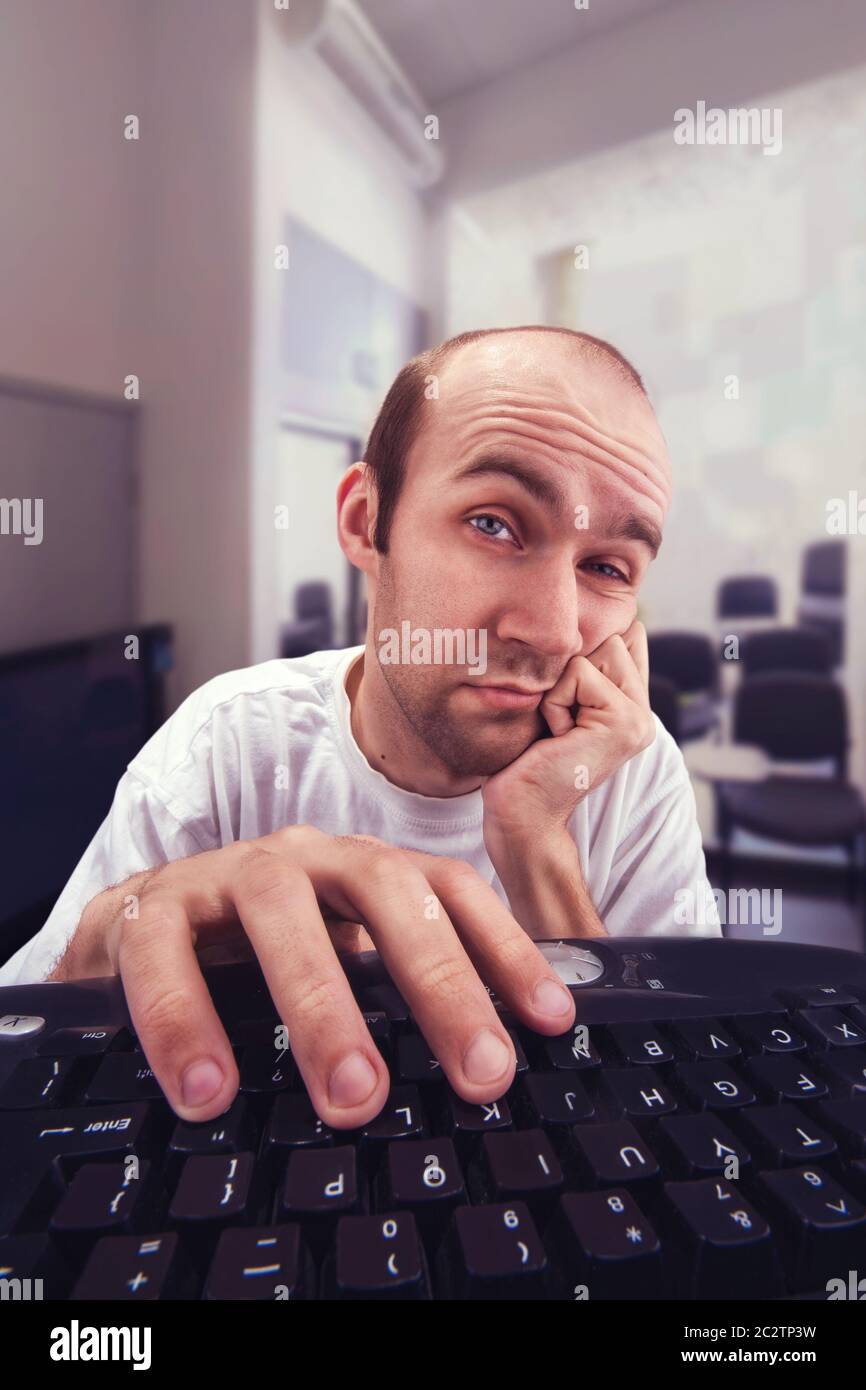 Assez indifférent homme travaillant avec l'ordinateur vous regarde Banque D'Images