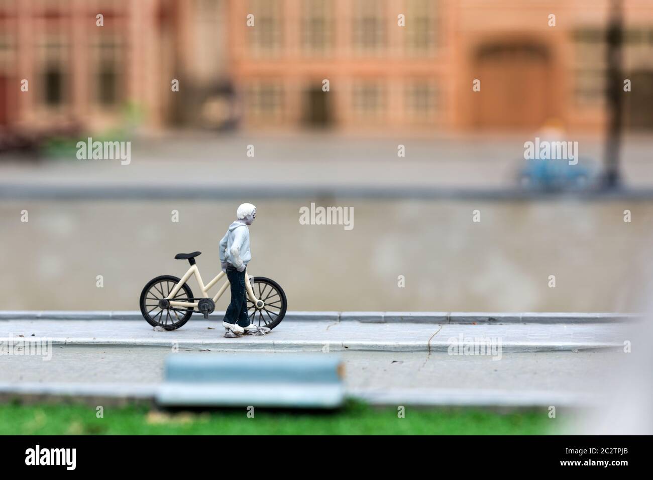 Homme avec vélo sur la rue de ville, scène miniature en plein air, europe. Mini chiffres avec délocalisation élevée des objets, diorama réaliste, modèle de jouet Banque D'Images