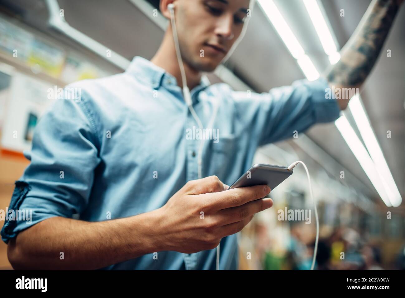 Jeune homme à l'aide de téléphones portables dans le métro, le problème de dépendance, une dépendance sociale, mode de vie souterrain moderne Banque D'Images