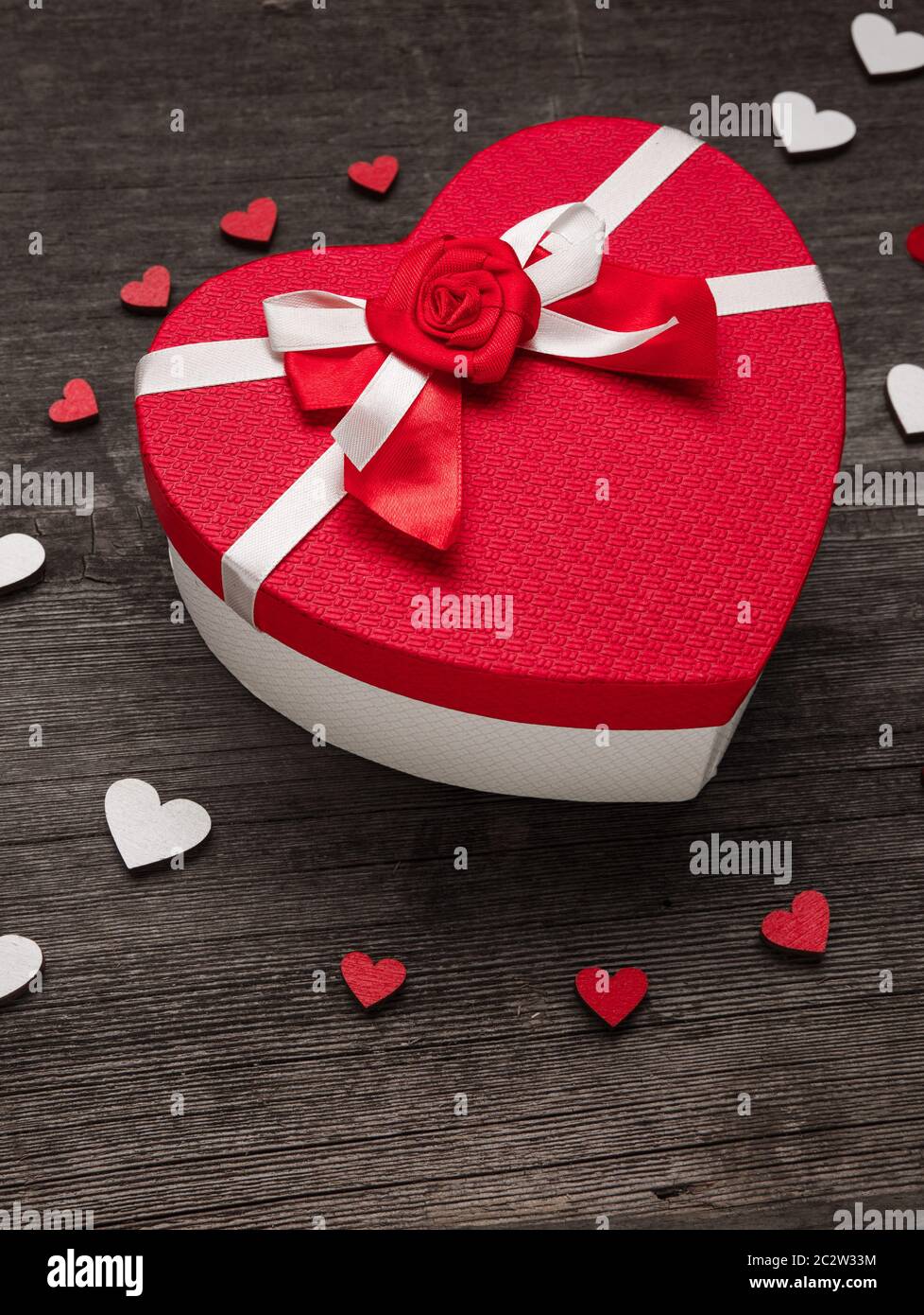 Le couvercle de la boîte en forme de coeur. Composition avec coeurs rouges et blancs sur fond en bois. Concept de la Saint-Valentin avec coeurs et gif Banque D'Images