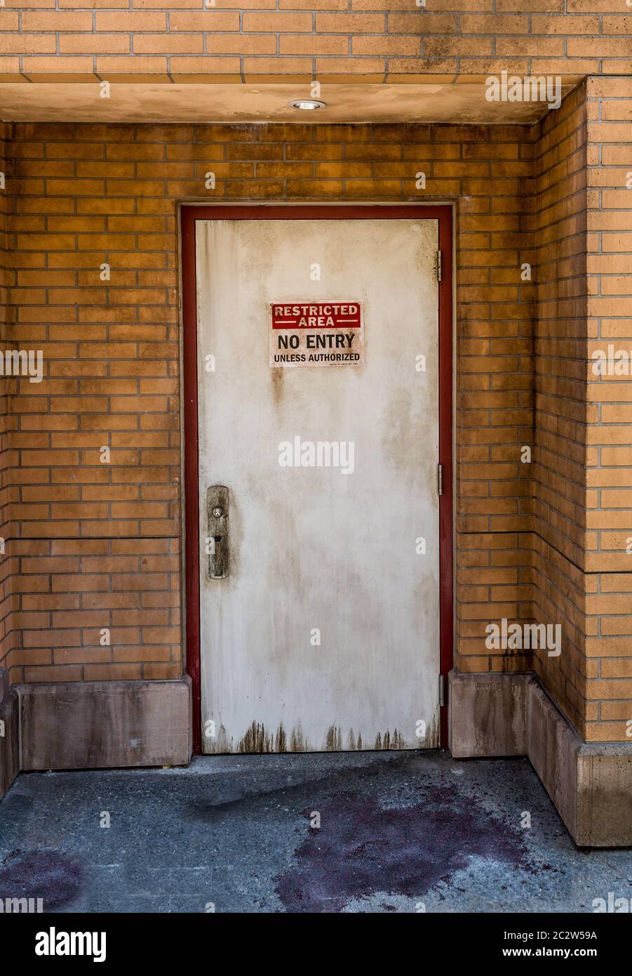 Grafez le mur et la porte en brique sans panneau d'entrée. Banque D'Images