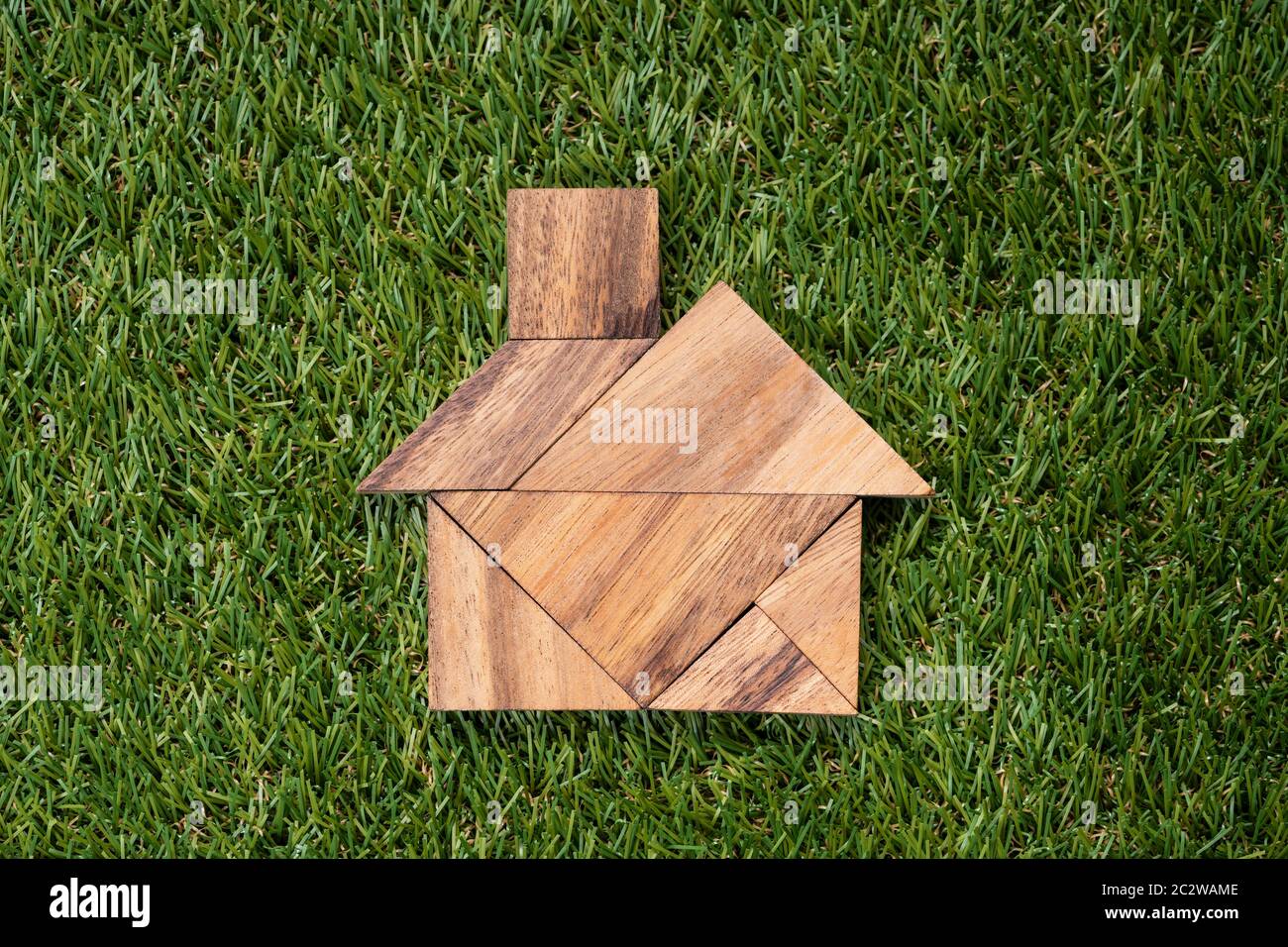 Portrait d'en-tête Tangram Accueil forme sur fond d'herbe verte artificielle Banque D'Images