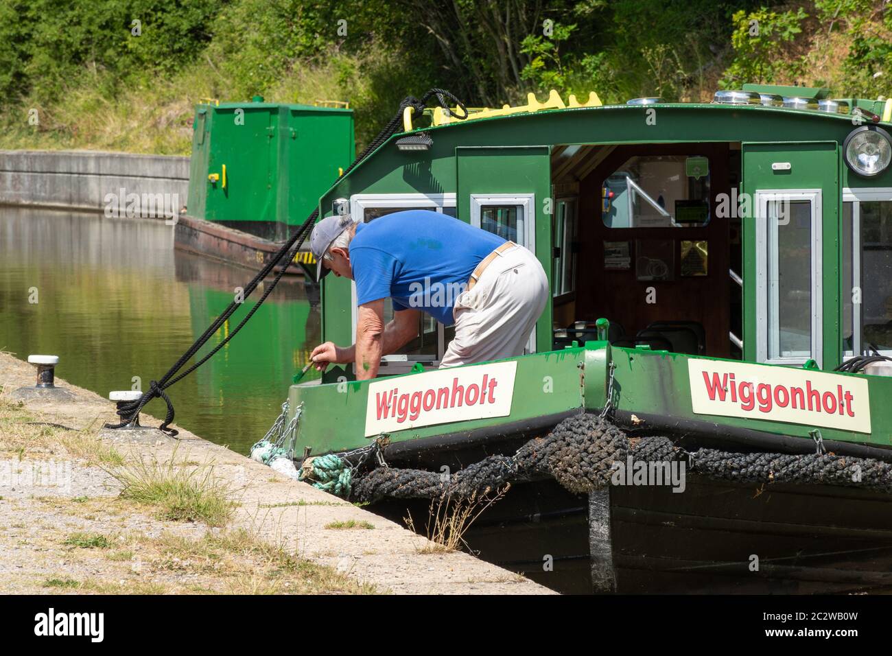 Wey et Arun Canal Trust travaillent bénévolement, homme peint un bateau à rames, West Sussex, Royaume-Uni Banque D'Images