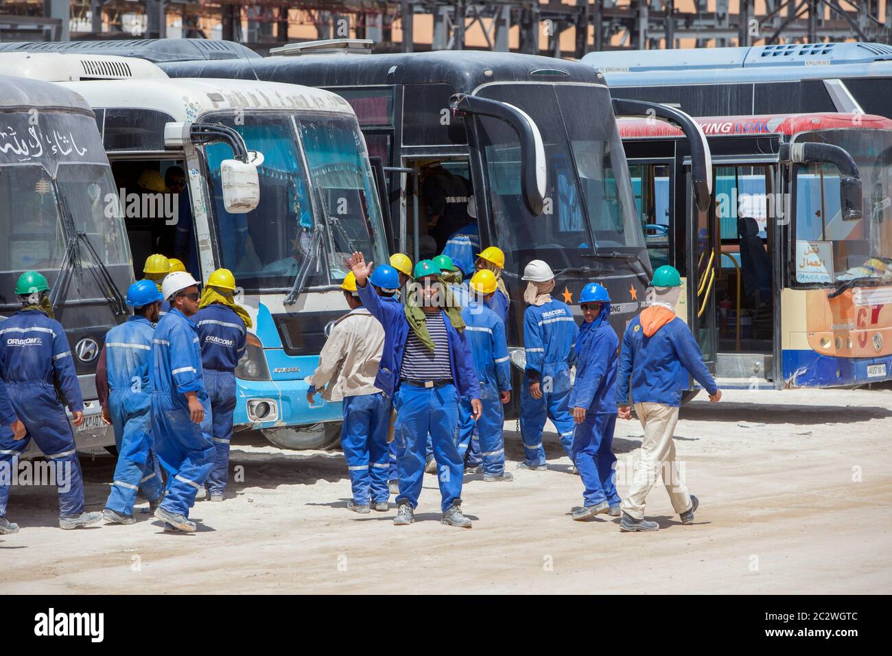 Les travailleurs sont transportés pour les emmener aux cantines pour le déjeuner tout en travaillant à la construction d'une importante installation pétrolière dans le désert du Sahara. Banque D'Images