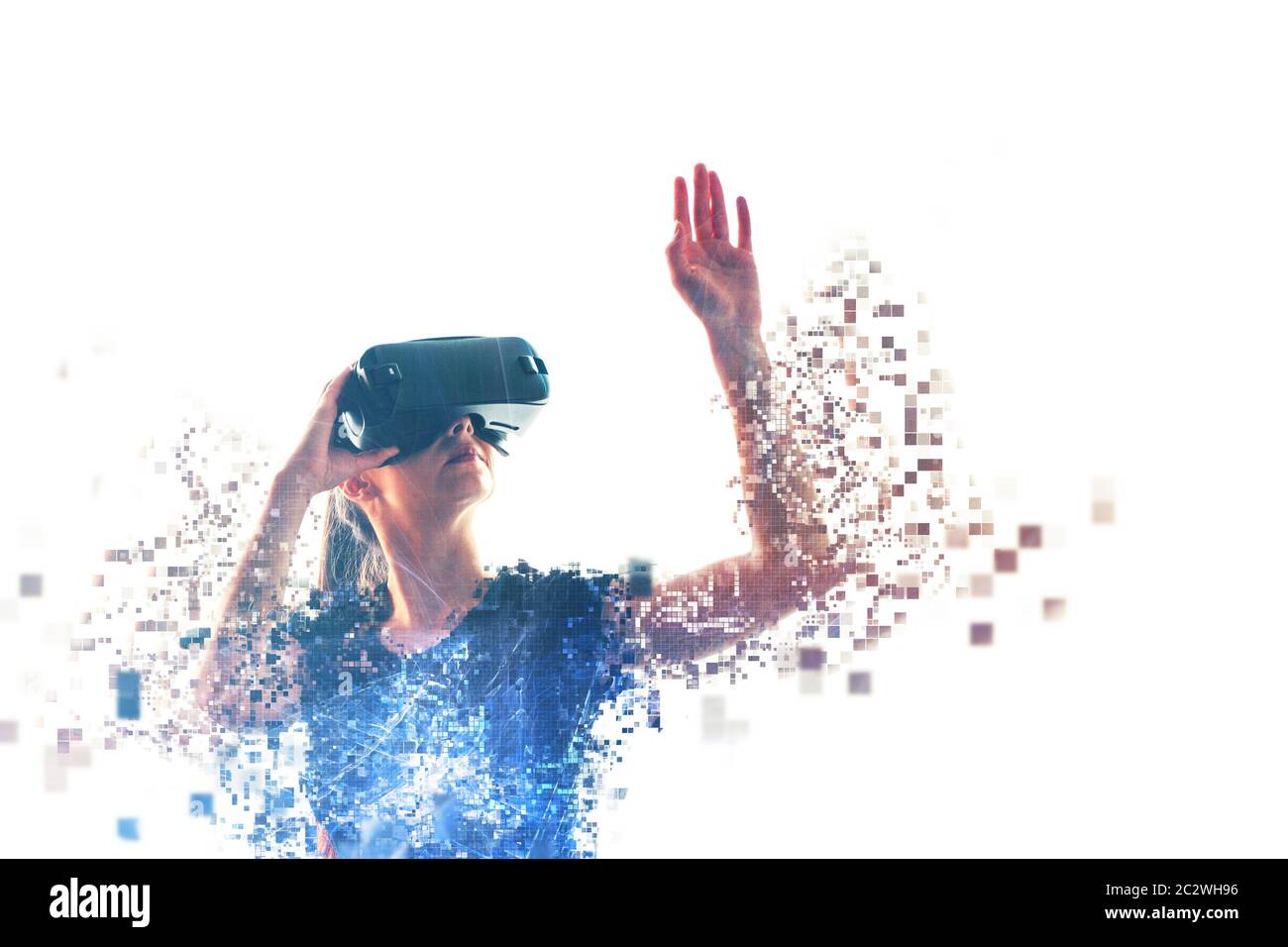 Une fille dans les lunettes de réalité virtuelle est pixélisée ou dispersée en pixels. Concept VR. Technologies modernes. Banque D'Images