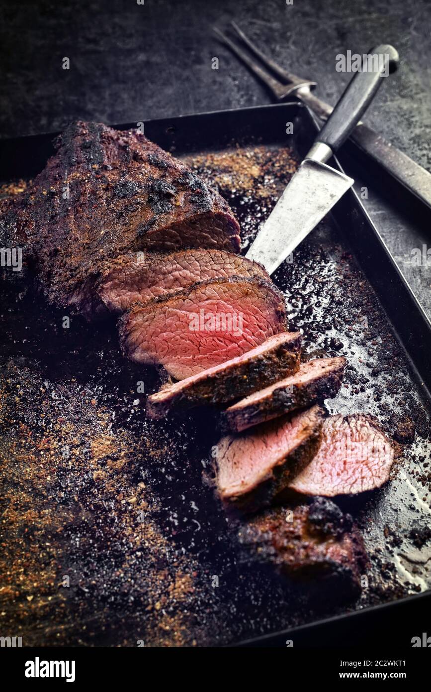 Griller un steak Wagyu vieilli à trois pointes avec un chiffon pour griller comme un gros plan sur une tôle noire Banque D'Images