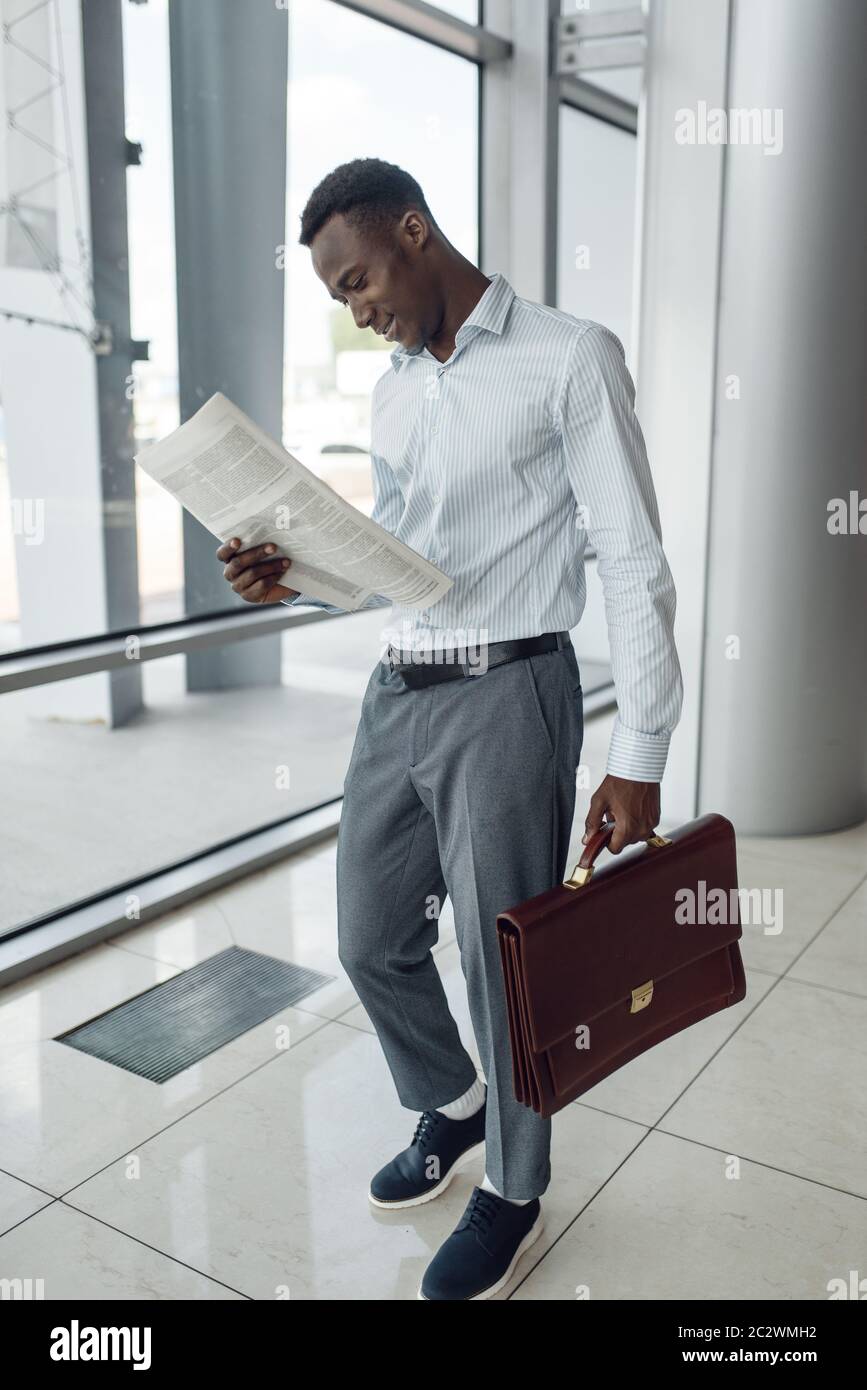 Homme d'affaires noir avec porte-documents lisant le journal, centre  commercial. Personne d'affaires réussie, homme noir en tenue formelle,  centre commercial Photo Stock - Alamy