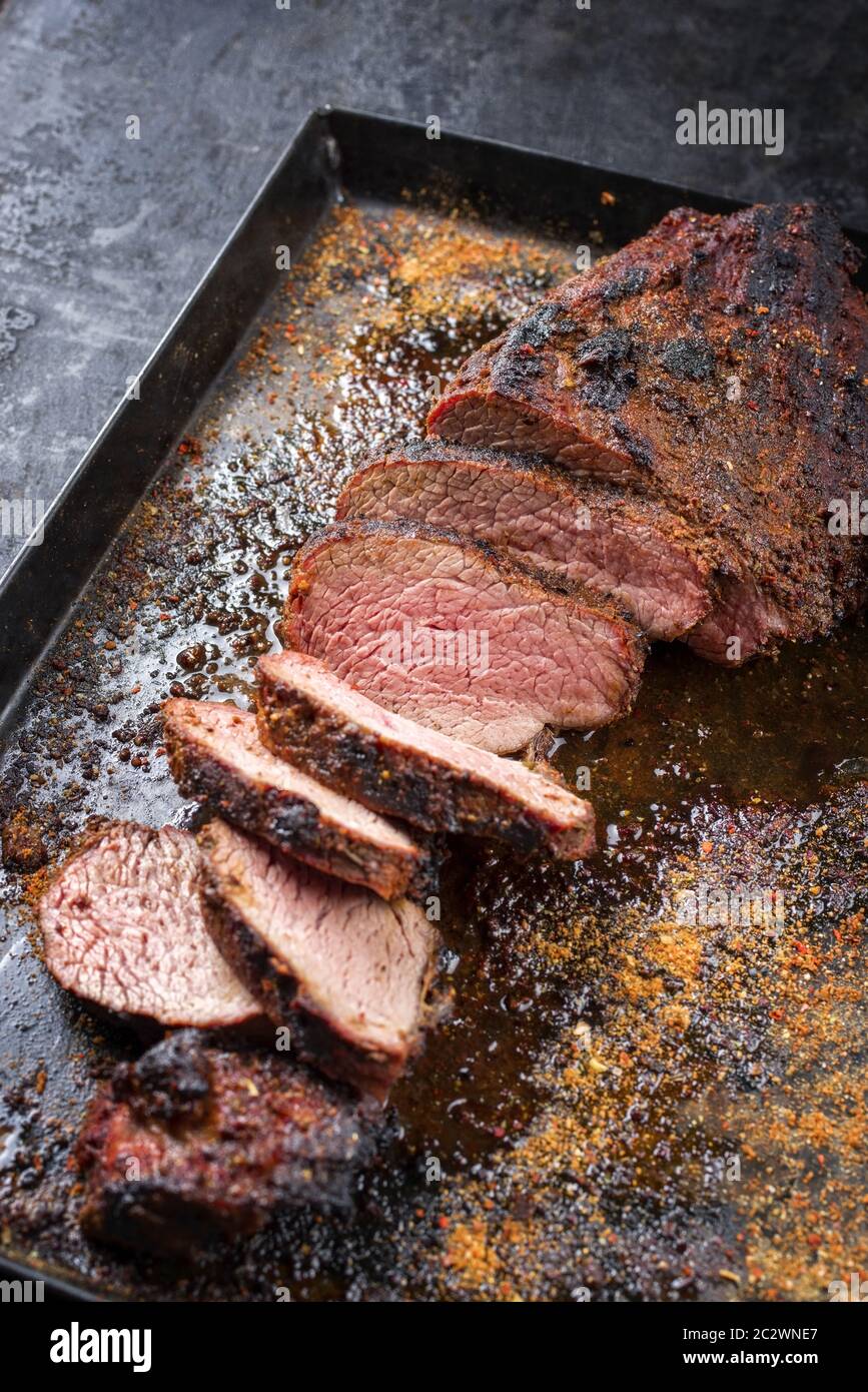 Griller un steak Wagyu vieilli à trois pointes avec un chiffon pour griller comme un gros plan sur une tôle noire Banque D'Images