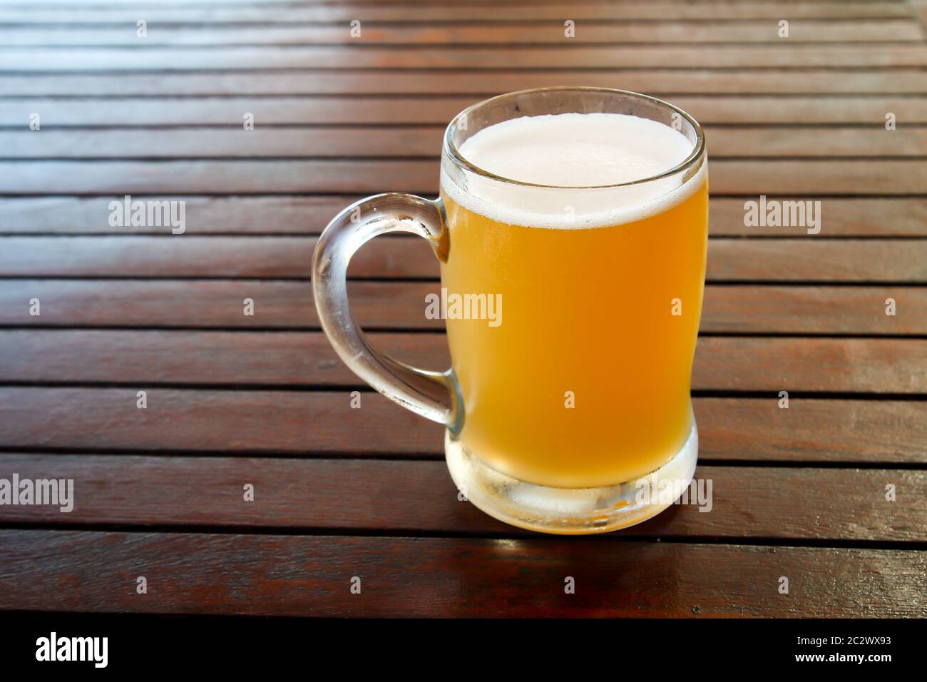 un verre rempli de bière sur une table Banque D'Images