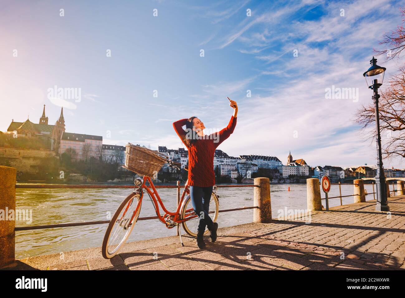 Une belle jeune femme avec un vélo rouge rétro fait une photo d'elle-même dans la vieille ville d'Europe sur l'éban du Rhin Banque D'Images