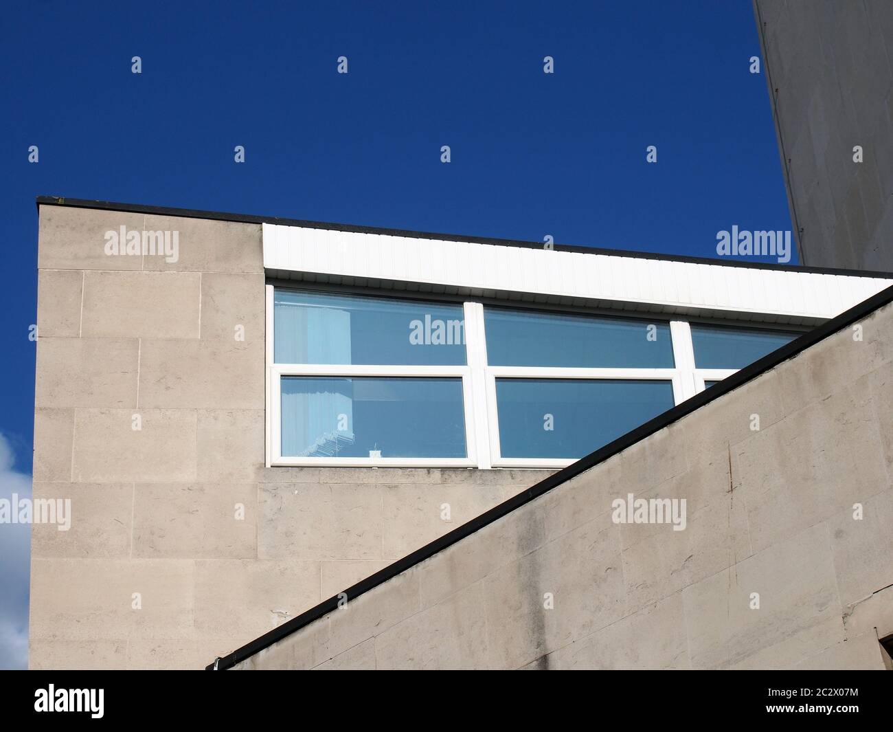 vue angulaire d'un vieux bâtiment en style brutaliste en béton des années 1960 avec ciel bleu Banque D'Images