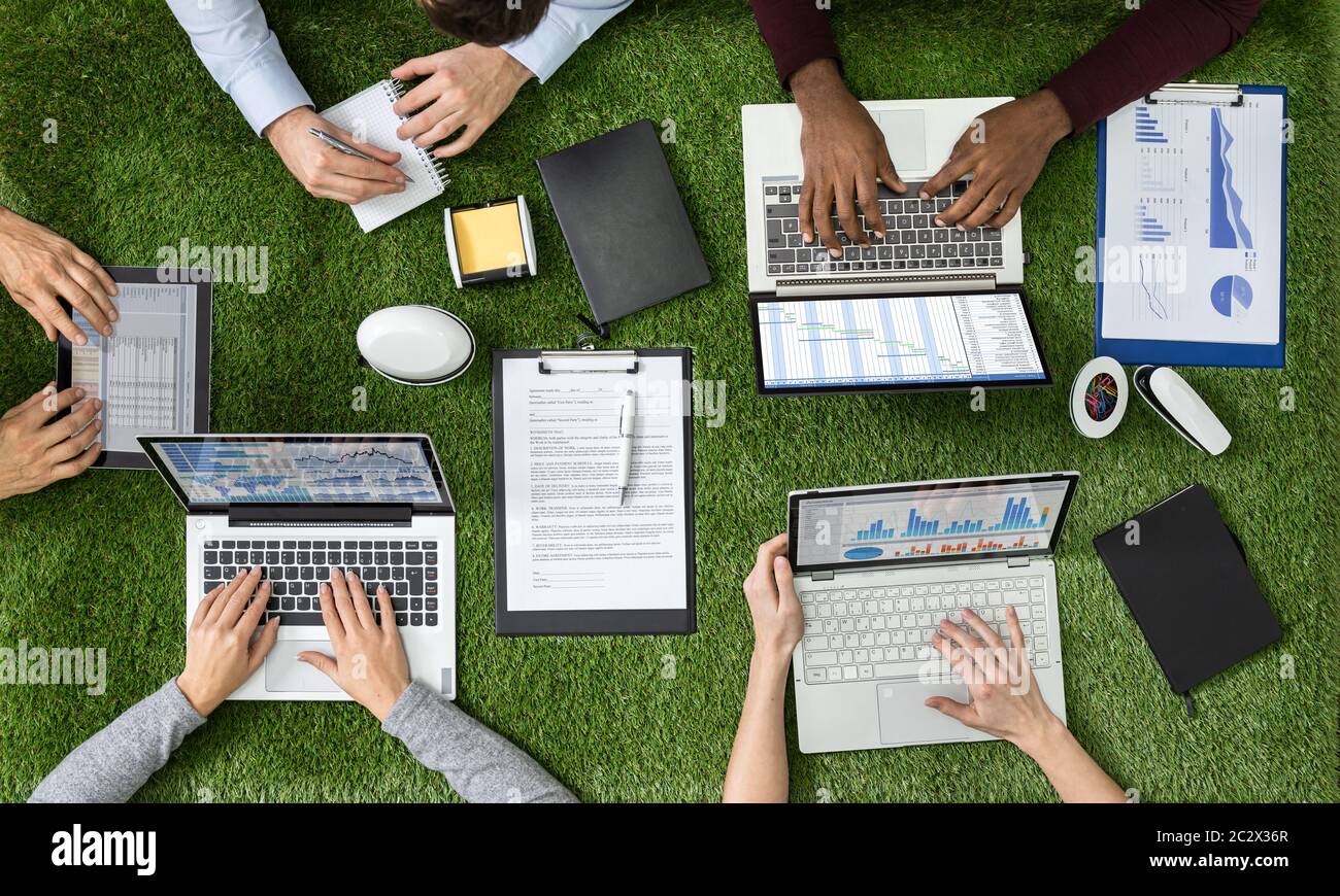 Vue Aérienne Des Hommes D'Affaires Sur L'Herbe Avec Les Ordinateurs Portables Et Le Travail Sur Tablette Numérique Banque D'Images