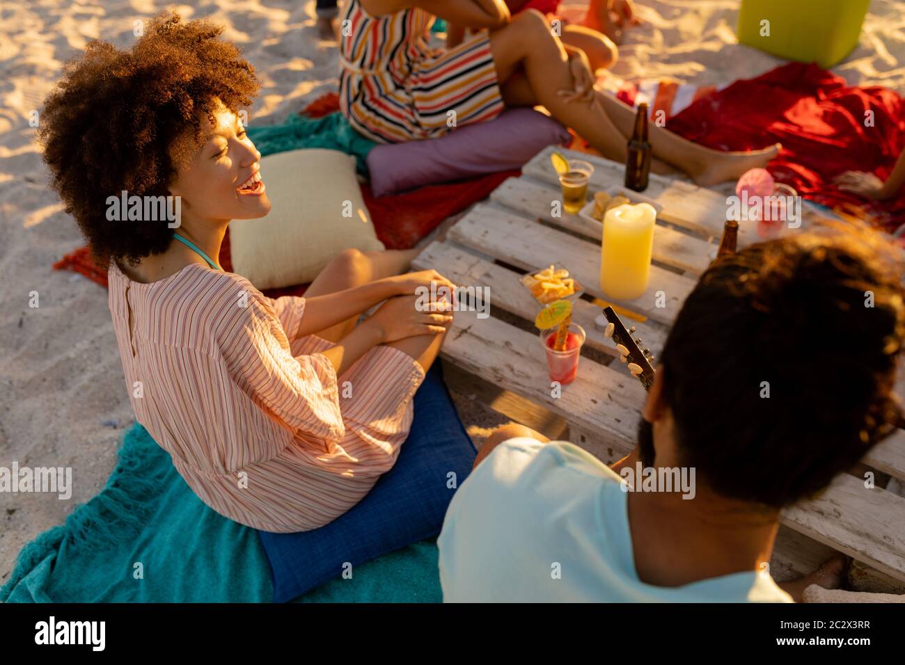 Groupe d'amis de course mixte s'amusant sur la plage Banque D'Images