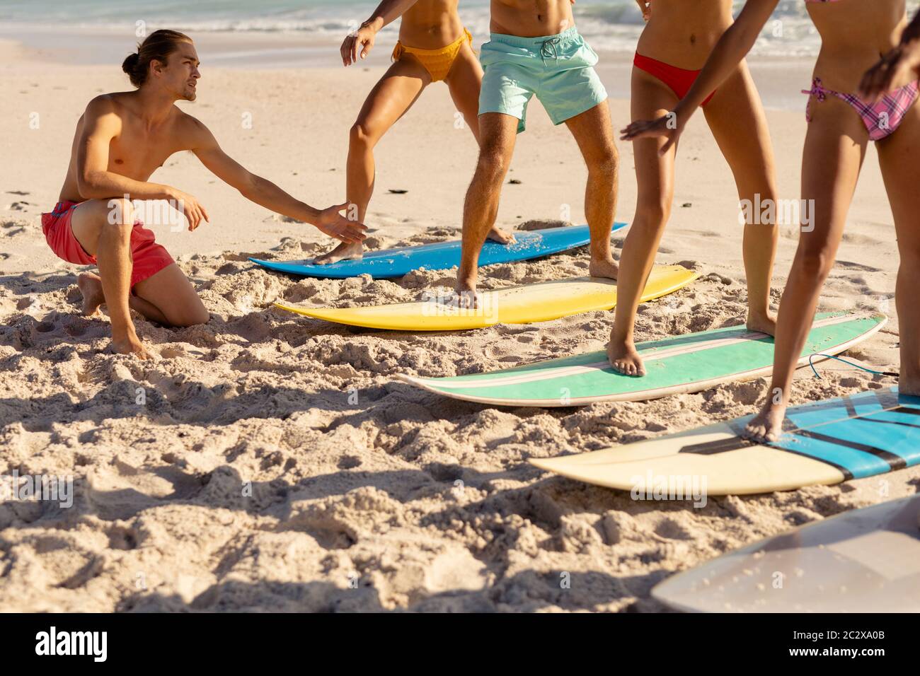 Groupe multiethnique de hommes et de femmes, surf sur la plage Banque D'Images