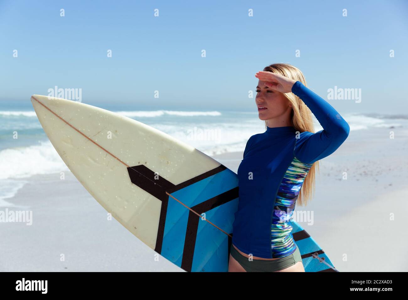 Femme caucasienne pendant la session de surf à la plage Banque D'Images