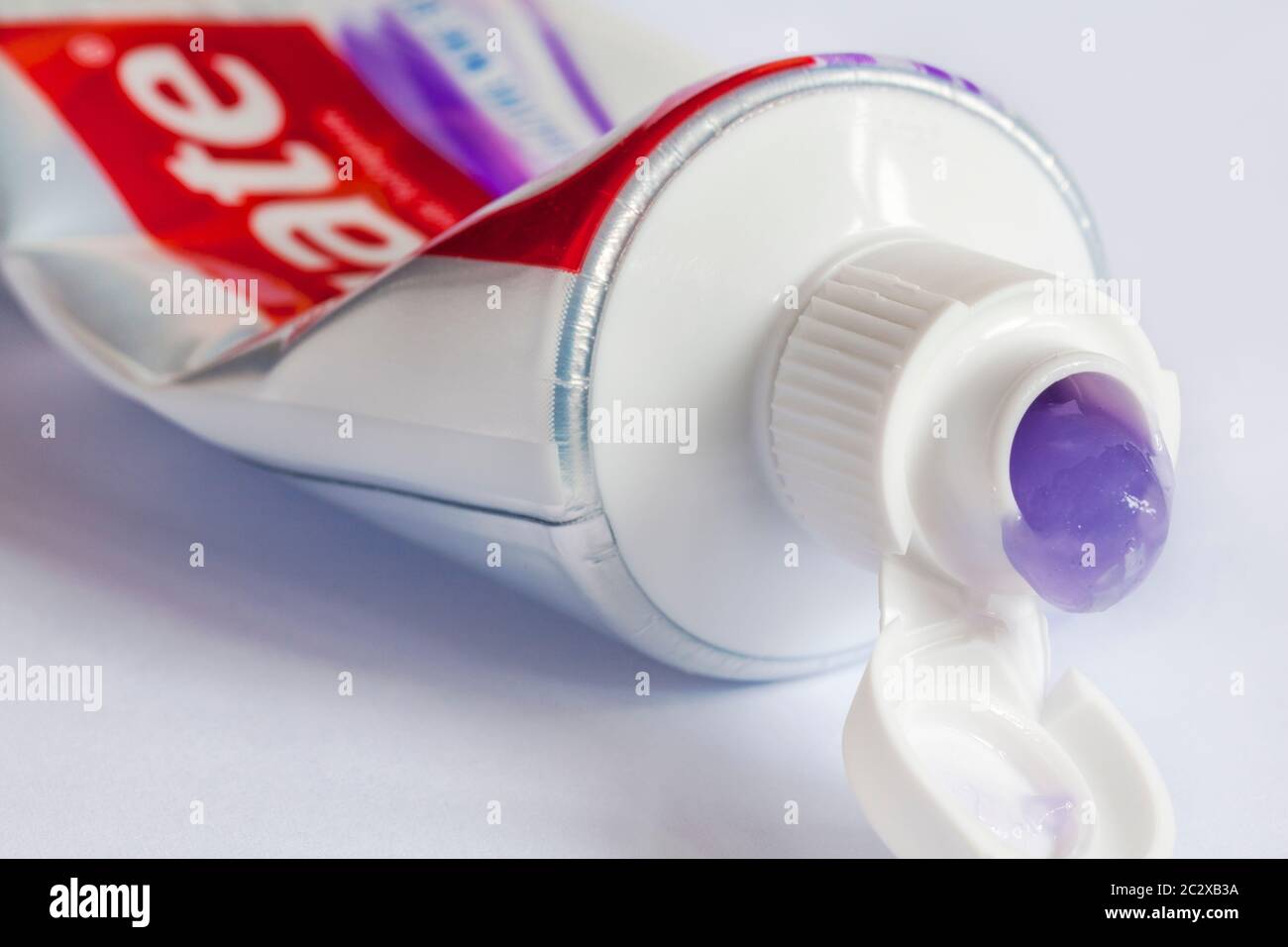 BLOB de Colgate MaxWhite Shine Crystals dentifrice au fluorure suining de tube sur fond blanc - dentifrice violet Banque D'Images