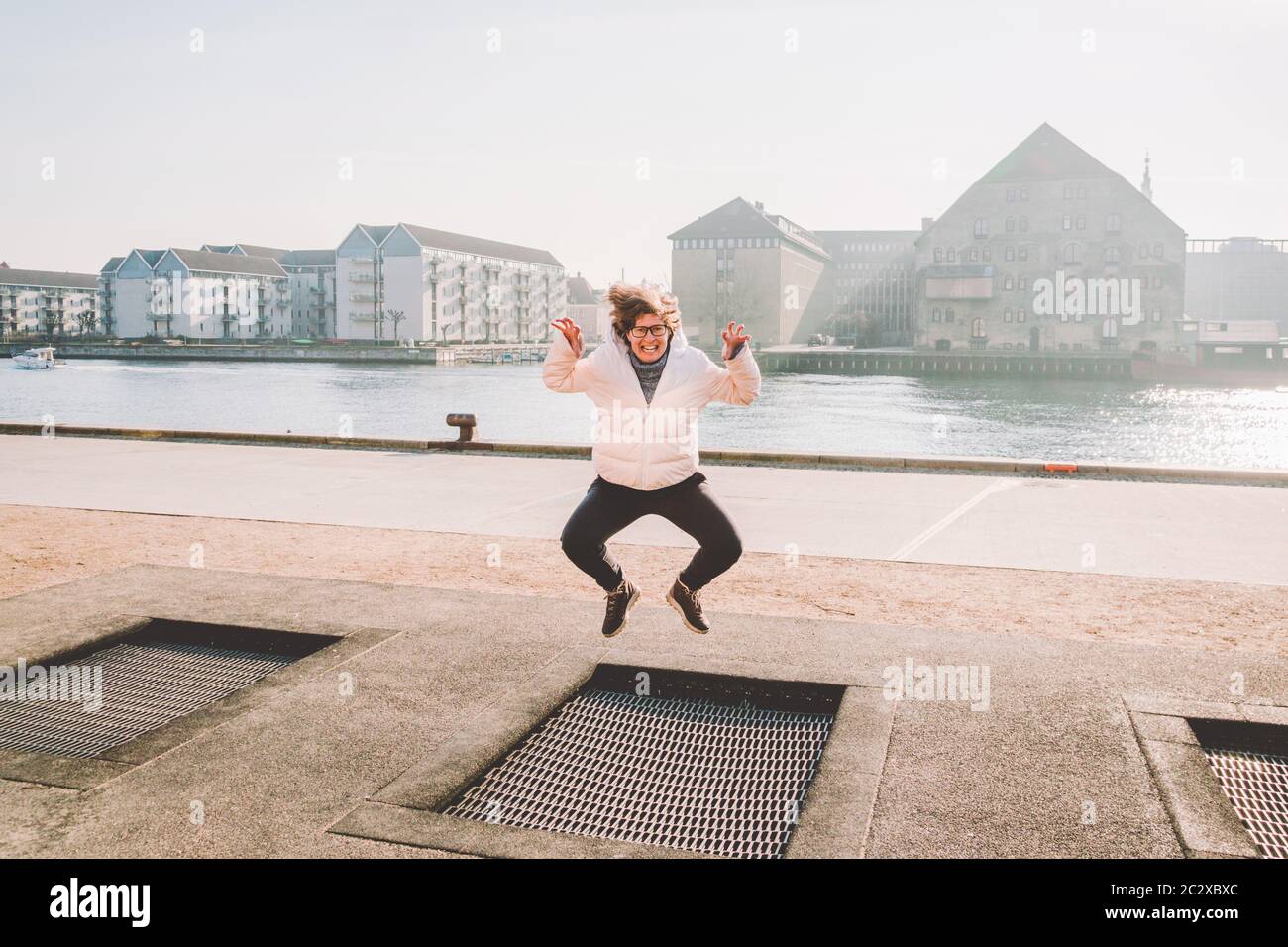 la personne adulte se réjouit comme l'enfant. Terrain de jeu trampoline dans le sol, enfants trampoline, ressorts jette les gens à s'amuser et cool. C Banque D'Images