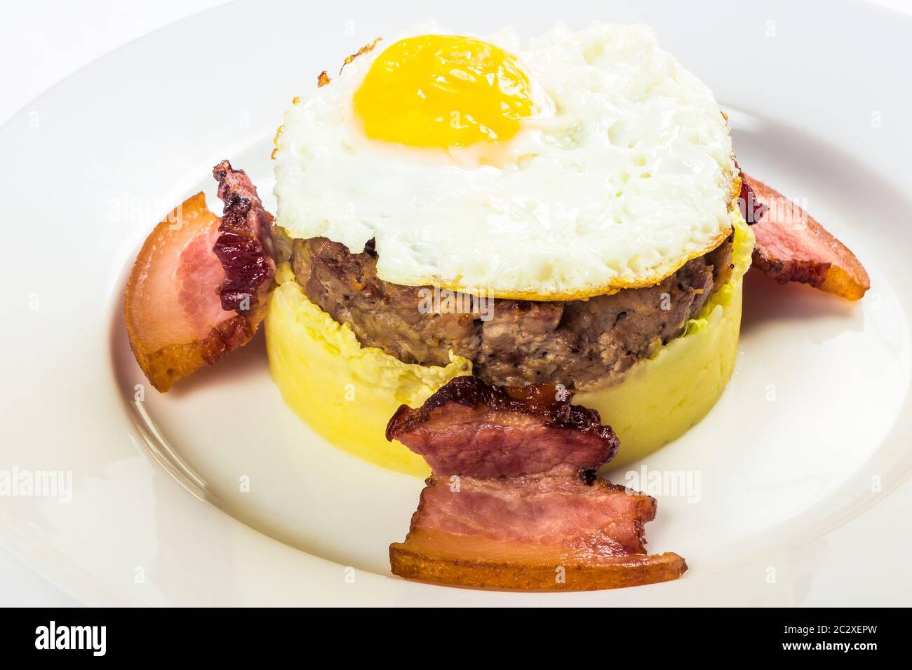 petit déjeuner à la mémoire des mères. viande et œufs frits sur une purée de pommes de terre, au bacon. nourriture isolée sur fond blanc. vue rapprochée Banque D'Images