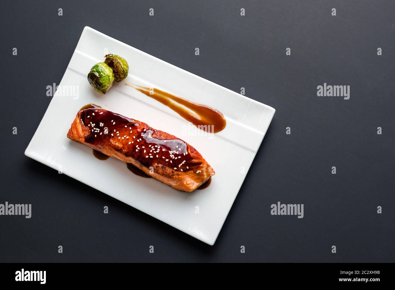 Cuisine japonaise cuisine inspirée de filets de saumon grillés, émaillés de délicieux mets teriyaki (base de sauce soja) et choux de Bruxelles sur une assiette blanche. Banque D'Images Cuisine japonaise cuisine inspirée de filets de saumon grillés, émaillés de délicieux mets teriyaki (base de sauce soja) et choux de Bruxelles sur une assiette blanche. Banque D'Images