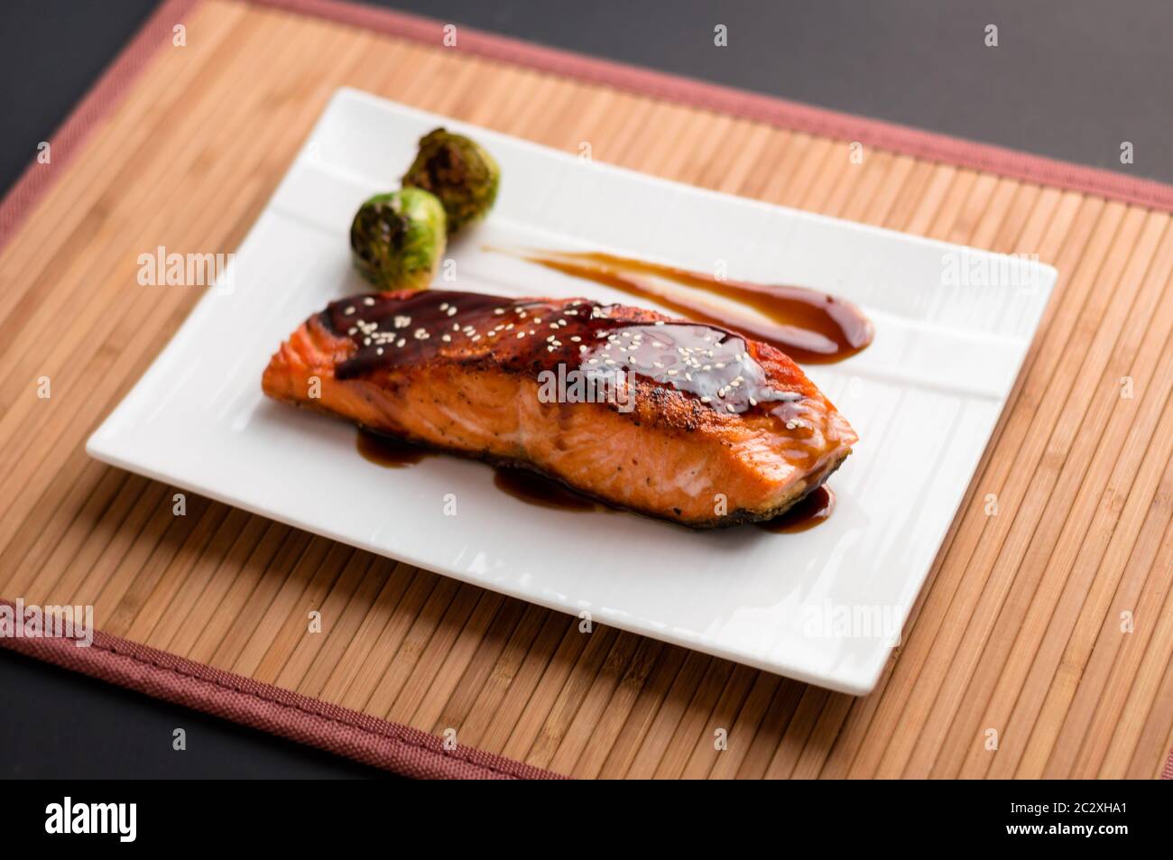 Cuisine japonaise cuisine inspirée de filets de saumon grillés, émaillés de délicieux mets teriyaki (base de sauce soja) et choux de Bruxelles sur une assiette blanche. Banque D'Images Cuisine japonaise cuisine inspirée de filets de saumon grillés, émaillés de délicieux mets teriyaki (base de sauce soja) et choux de Bruxelles sur une assiette blanche. Banque D'Images