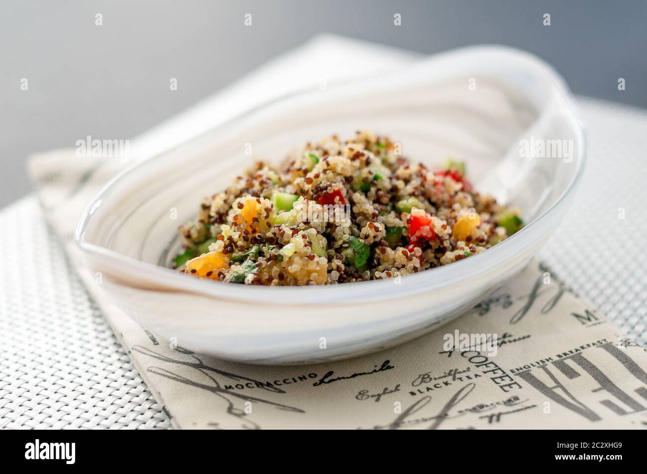 Bol à salade de quinoa sur un tapis blanc. Les salades de quinoa sont très saines et faciles à faire! Le quinoa est un grain originaire de l'Amérique du Sud. Banque D'Images