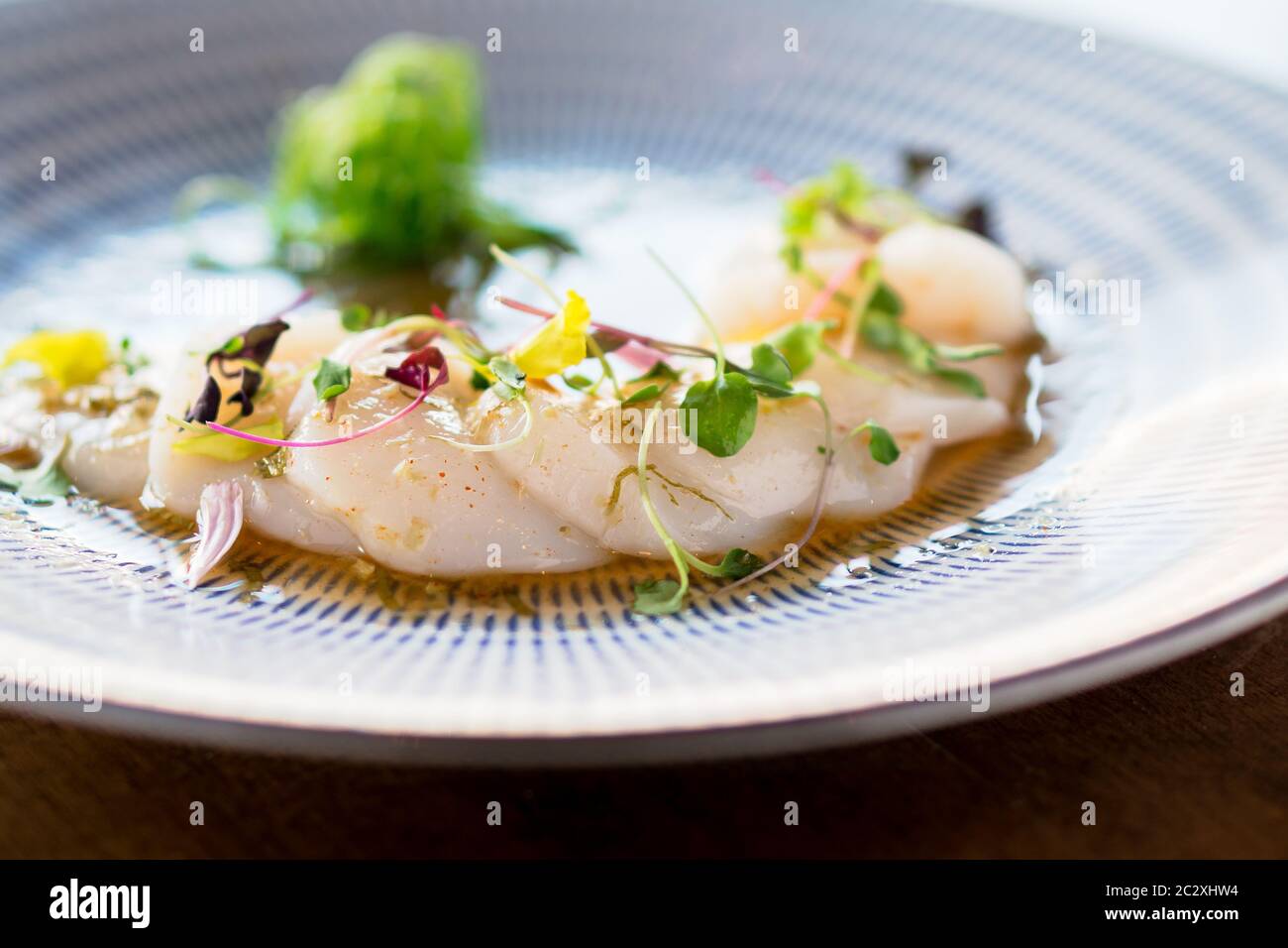 Saint-Jacques frais sashimi en gros plan. Plat de sashimi de pétoncles frais crus. Sashimi est une cuisine japonaise raffinée composée de viande hachée en tranches (généralement poisson an Banque D'Images