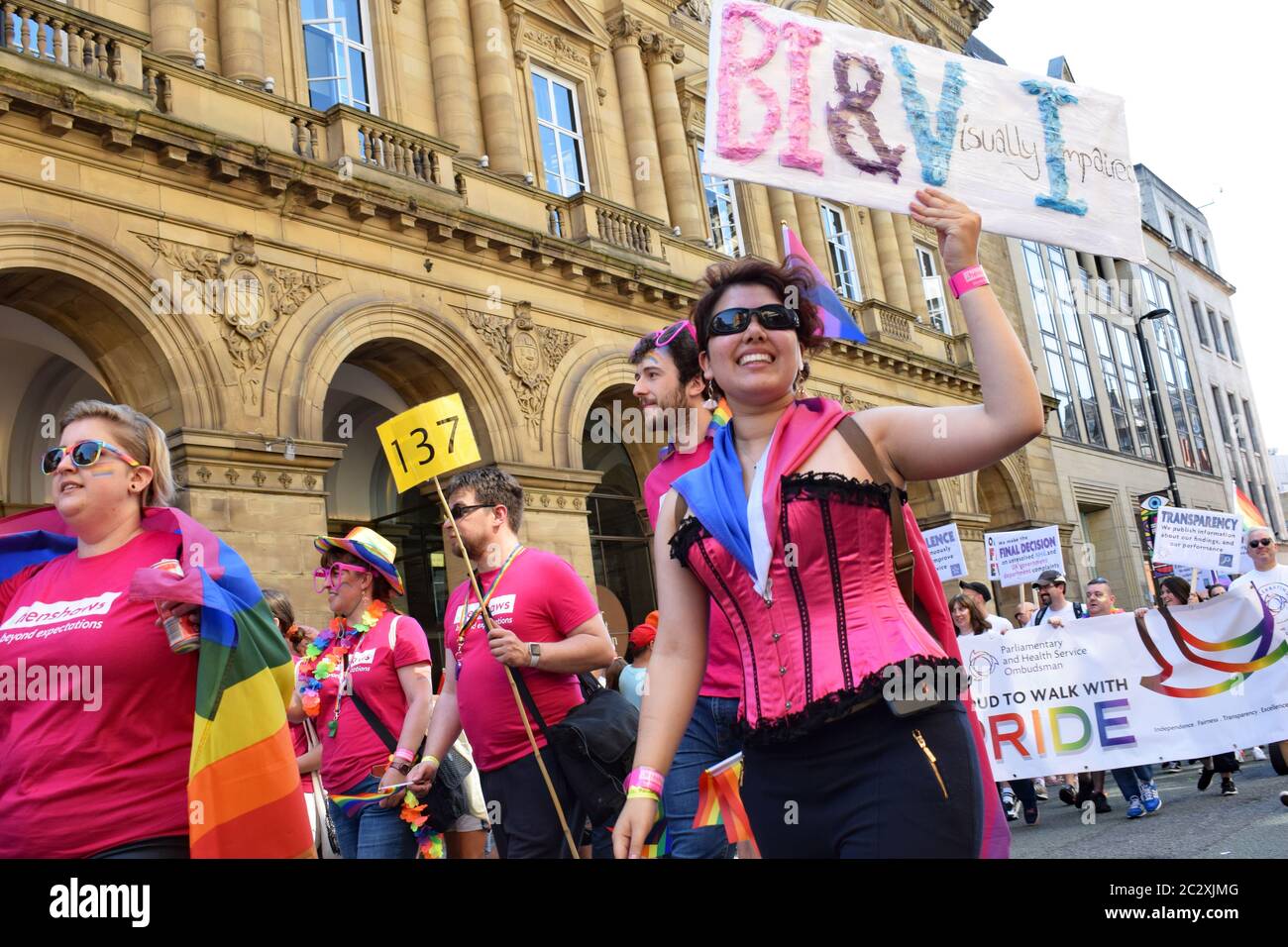 Défilé de fierté Manchester passant devant l'hôtel Radisson sur Peter Street une femme malvoyante en basque rose en procession tenant le signe BI&VI Banque D'Images
