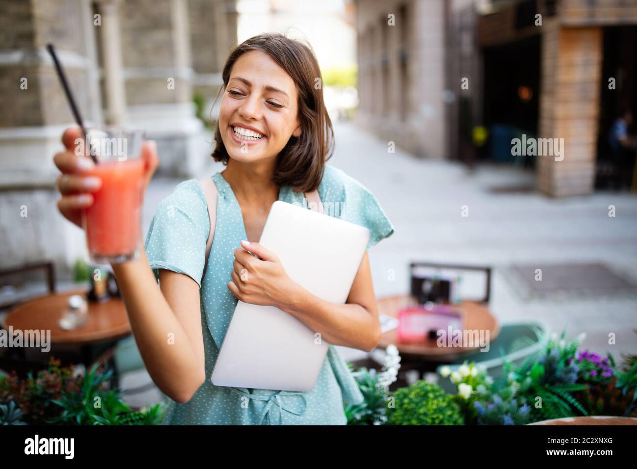 Portrait d'une belle gaie femme travaillant, étudiant sur un ordinateur portable Banque D'Images