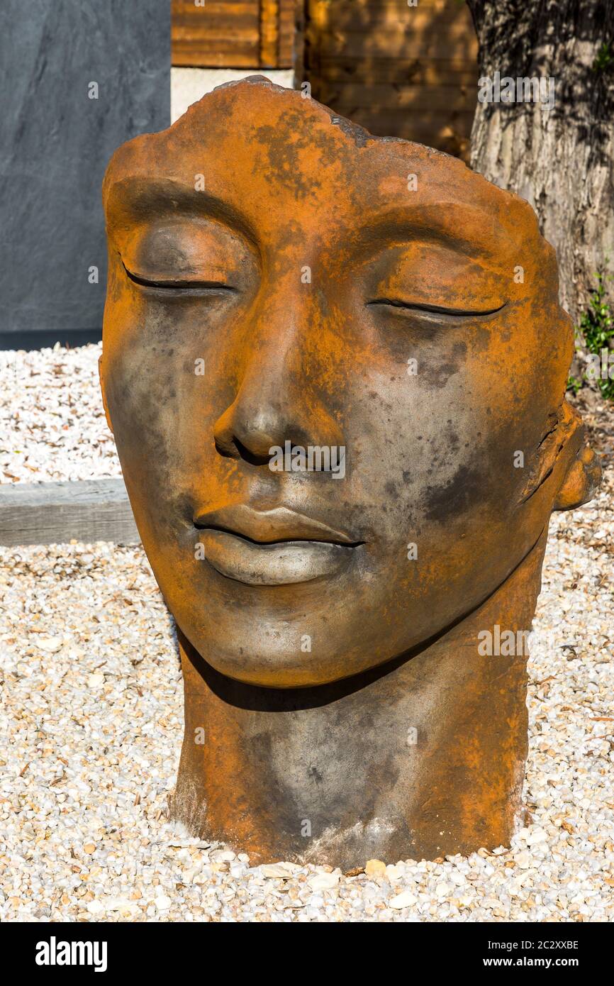 Sculpture de jardin en fonte avec intempéries, tête et visage orientaux  Photo Stock - Alamy
