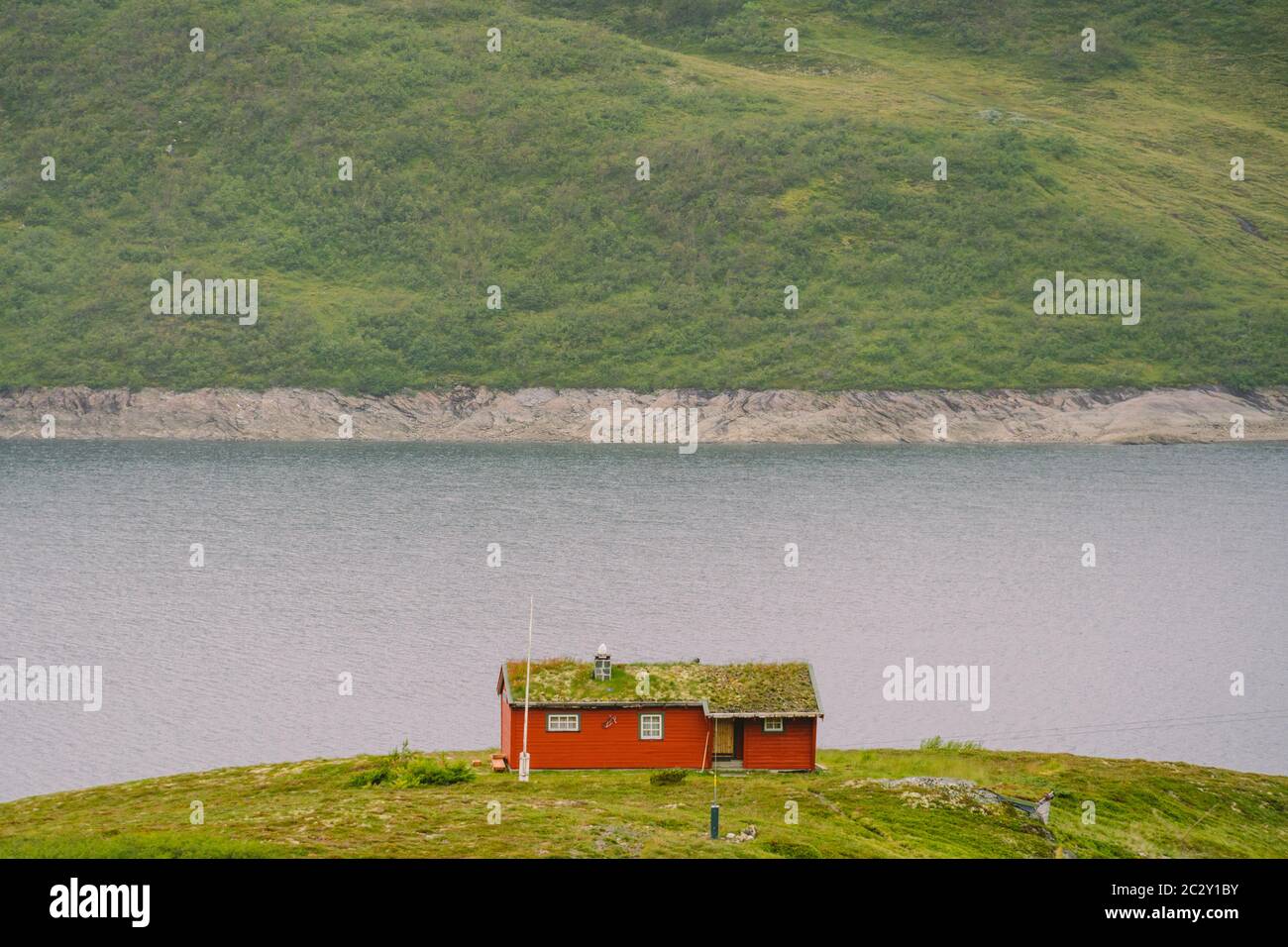 Maison d'été en bois norvégien surplombant le lac pittoresque, la Norvège, la Scandinavie. Cottage par lac en Rural. Cabane au toit de tourbe sur le lac. T Banque D'Images