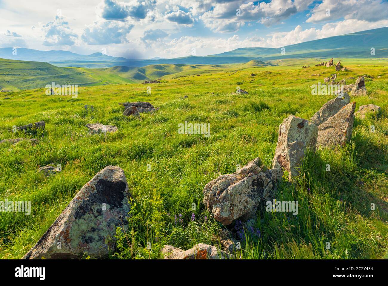 Un terrain vert succulent avec des pierres en Arménie, sur fond de montagnes, Zorats Karer, Stonehenge arménien Banque D'Images