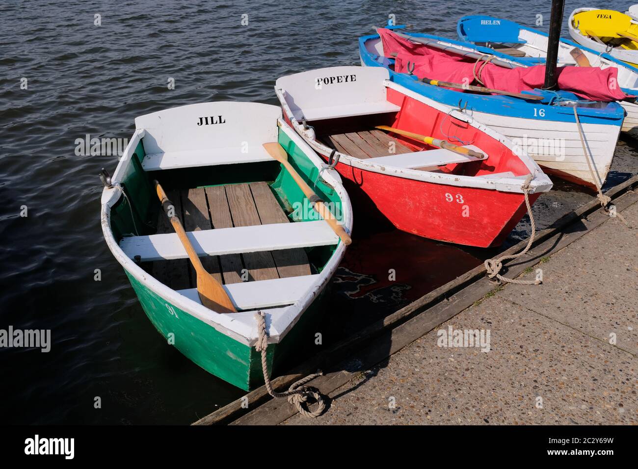 3 bateaux à rames multicolores amarrés sur le lac au soleil éclatant Banque D'Images