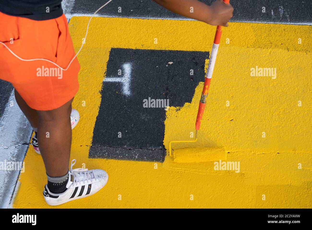 L'artiste de rue peint une fresque sur la 11th St est, près du centre-ville d'Austin, TX, qui dit « Black Artists Matters » deux jours après que le même groupe peint « Black Austin Matters » en grandes lettres jaunes sur Congress Avenue, au cœur du centre-ville. Banque D'Images