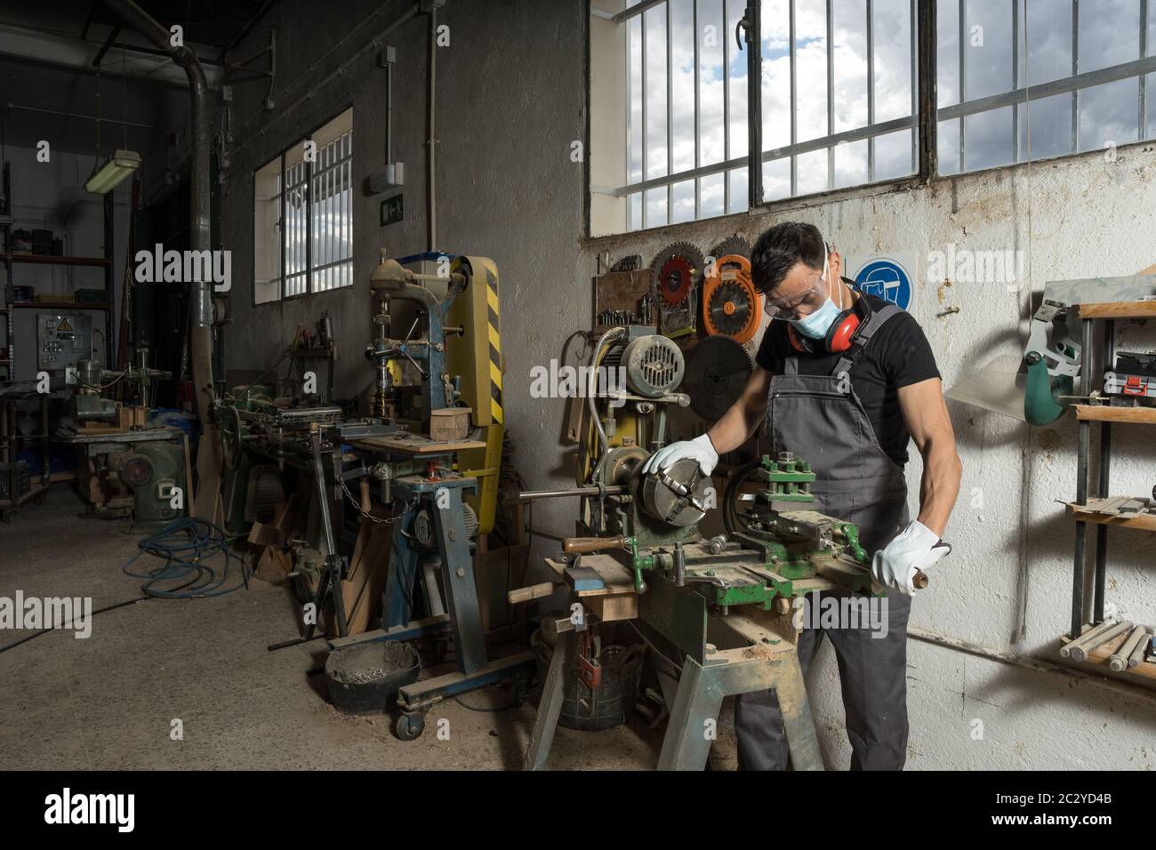 Travailleur debout avec un masque et un équipement de protection dans une usine. Photo intermédiaire. Banque D'Images