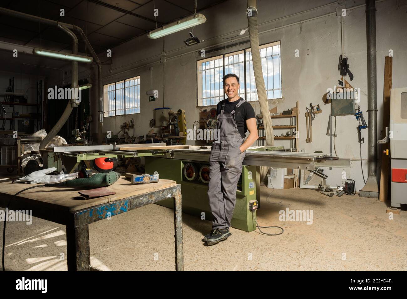 Un employé qui regarde la caméra sourire dans une usine. Photo longue, corps entier. Banque D'Images